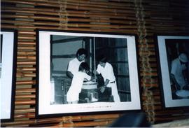Photograph of a framed photo depicting Japanese working a quern