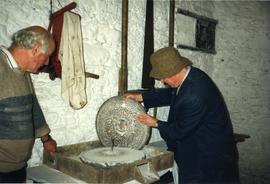 Photograph of Niall Roberts inspecting a handmill, Bunratty watermills, Tipperary, Ireland