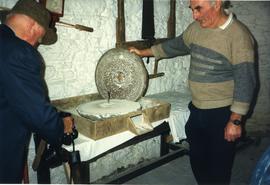 Photograph of Niall Roberts inspecting a handmill, Bunratty watermills, Tipperary, Ireland