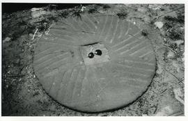 Photograph of a millstone set in the ground, South Africa