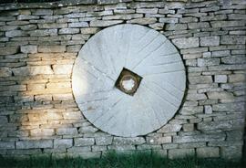 Photograph of a millstone in a wall, Slaughter Farm, Bourton on the Water, Gloucestershire