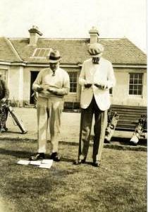 Two men inspecting cards before golf