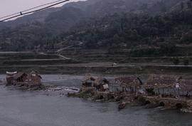 China, Chong-an. Sawdust mills in river.