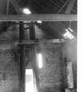 Derelict wind engine: timbers and gearing inside barn