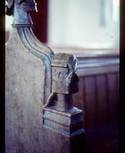 Carving of post mill on bench end in church