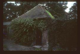 Small derelict brick building with pyramidal tiled roof