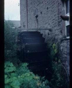 Exterior view of part of watermill building with wheel