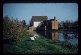 Exterior view of preserved watermill building by pond