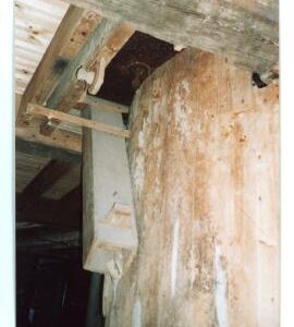 Evelith Mill, Shifnal - twist peg, meal spout, and levelling screw of a pair of stones, and part of cog pit boarding