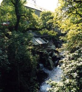 Looking upstream from road bridge, showing turbine house below mill, Penmachno Woollen Mill, Penmachno, Caernarvonshire